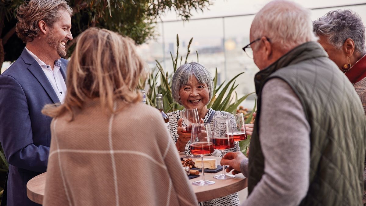 Senior living residents enjoying wine at a happy hour.