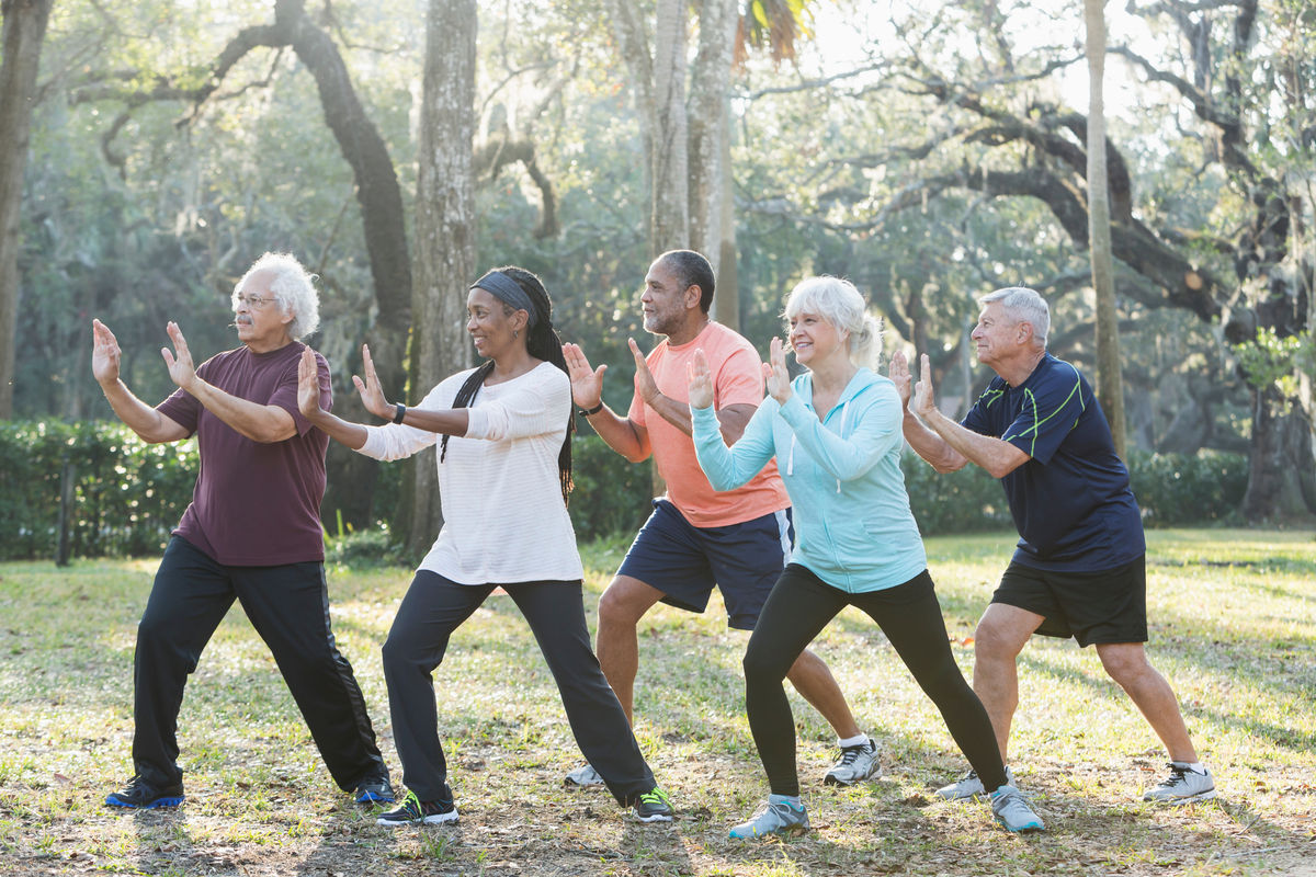 Several people exercise together outdoors