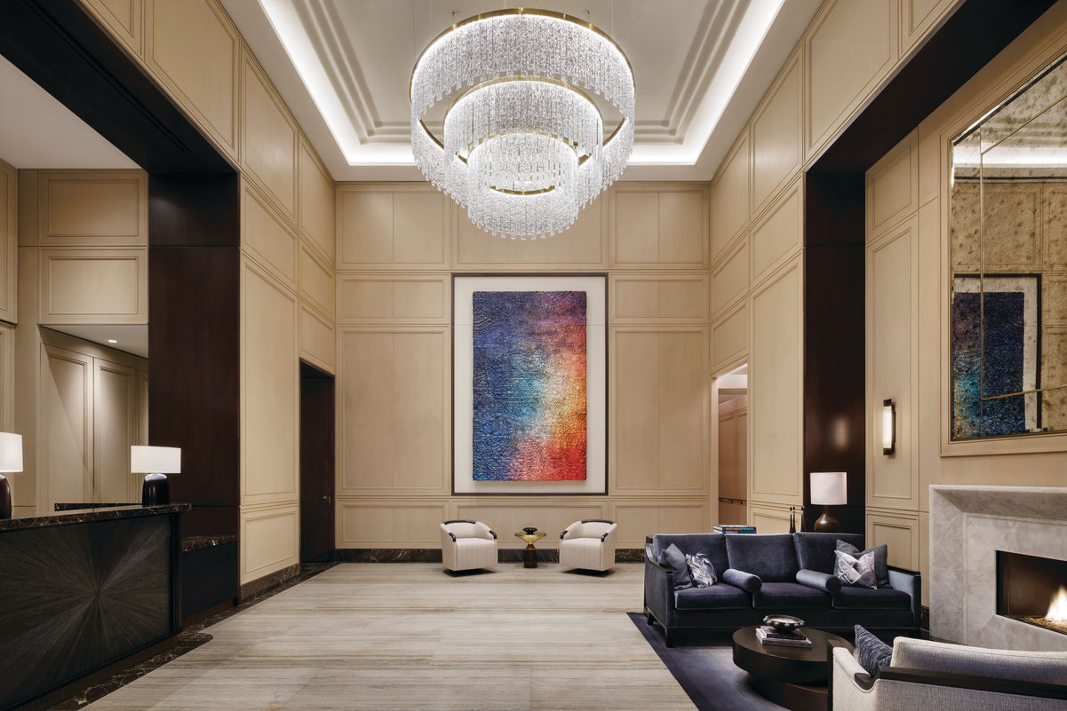 Elegantly displayed artwork in Hudson yards lobby with large crystal chandelier and fireplace