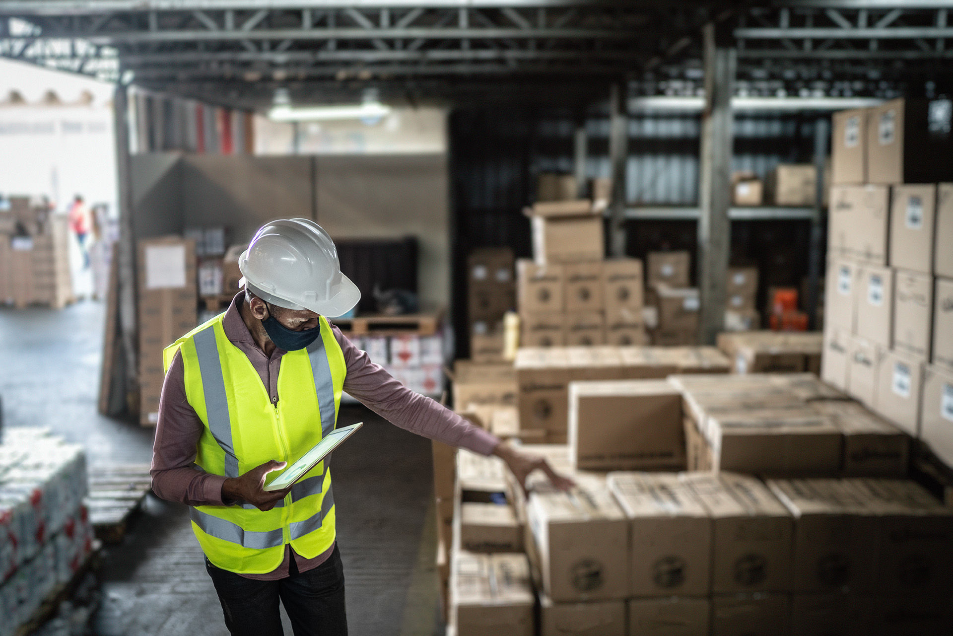Man in hardhat working with boxes  in storage area